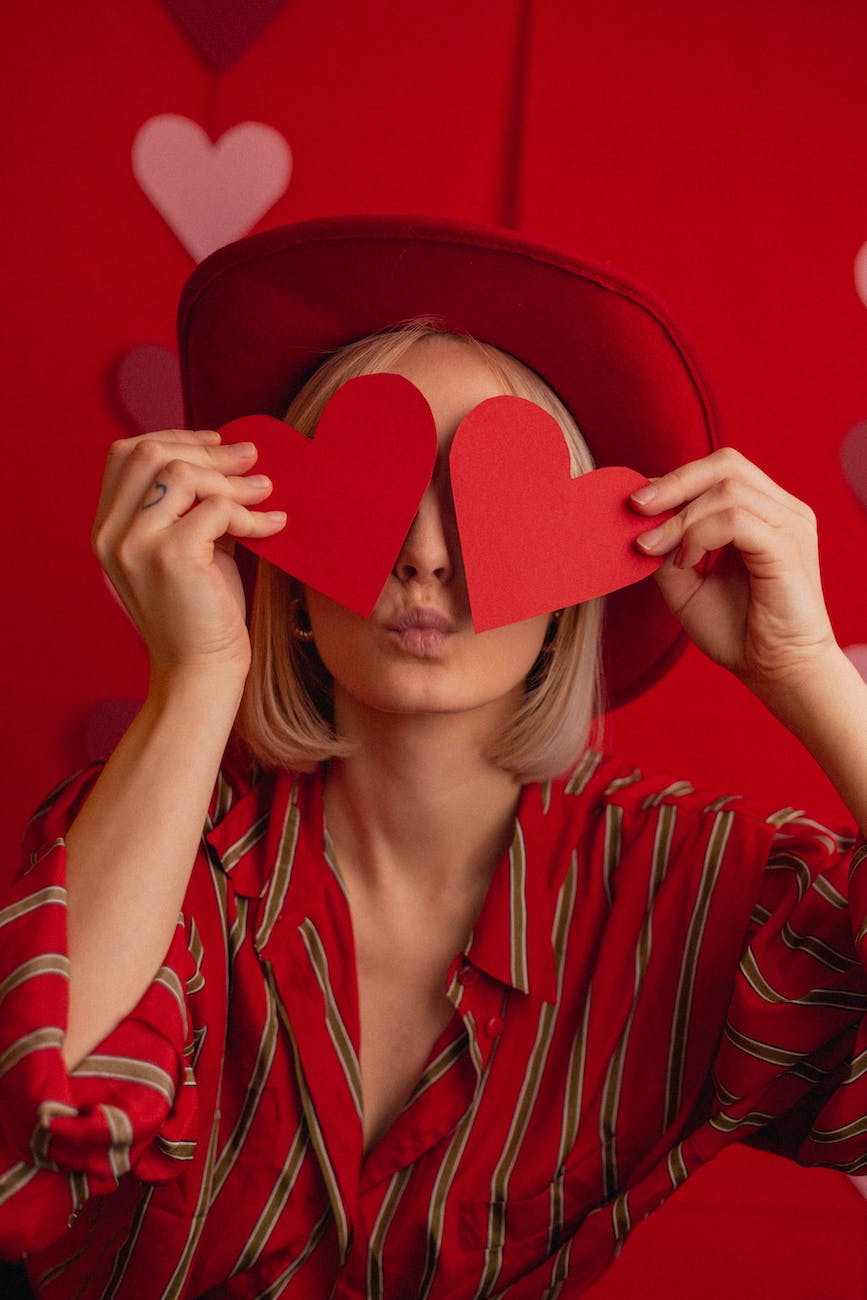 woman covering eyes with red hearts