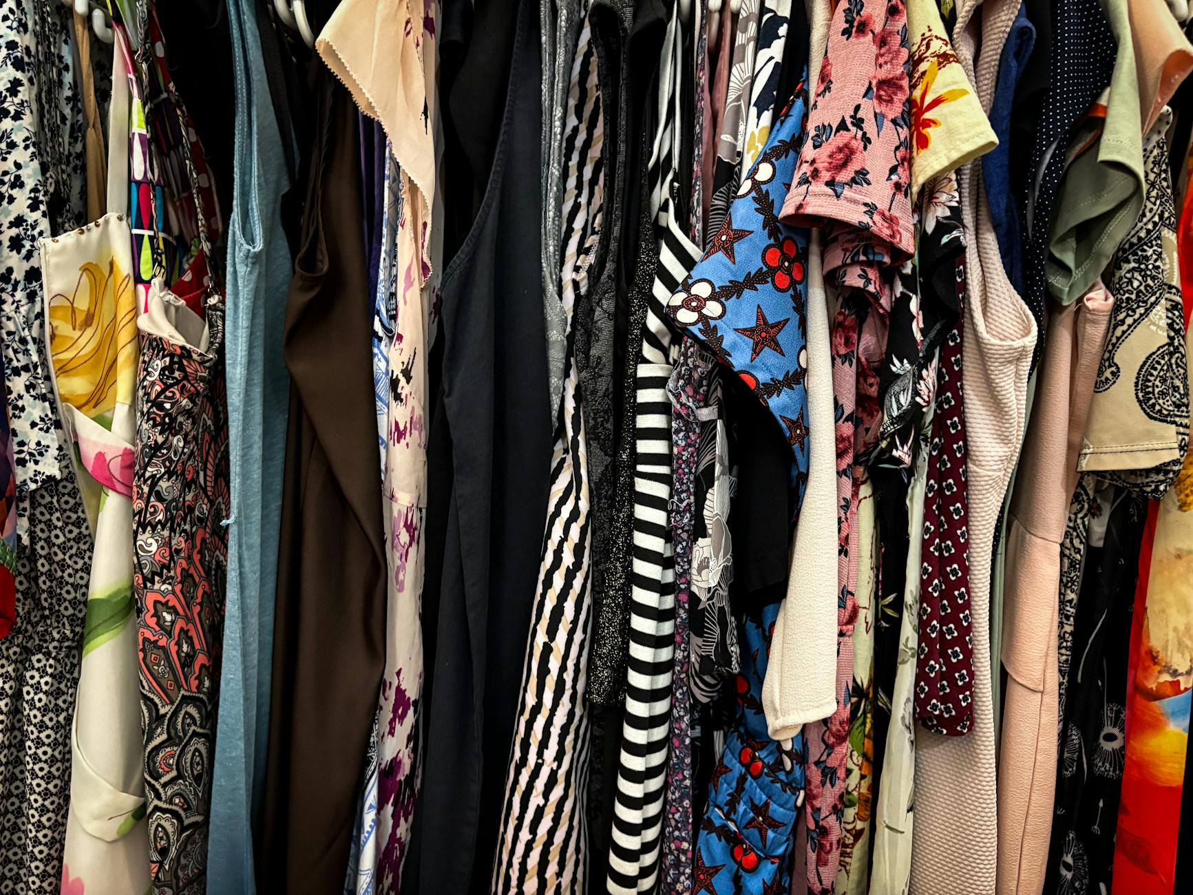 colorful rack of vintage clothes for thrifting